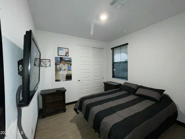 a bedroom with double bed and a flat tv screen on a dresser