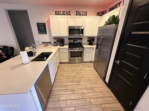 a kitchen with stainless steel appliances a refrigerator and a stove top oven
