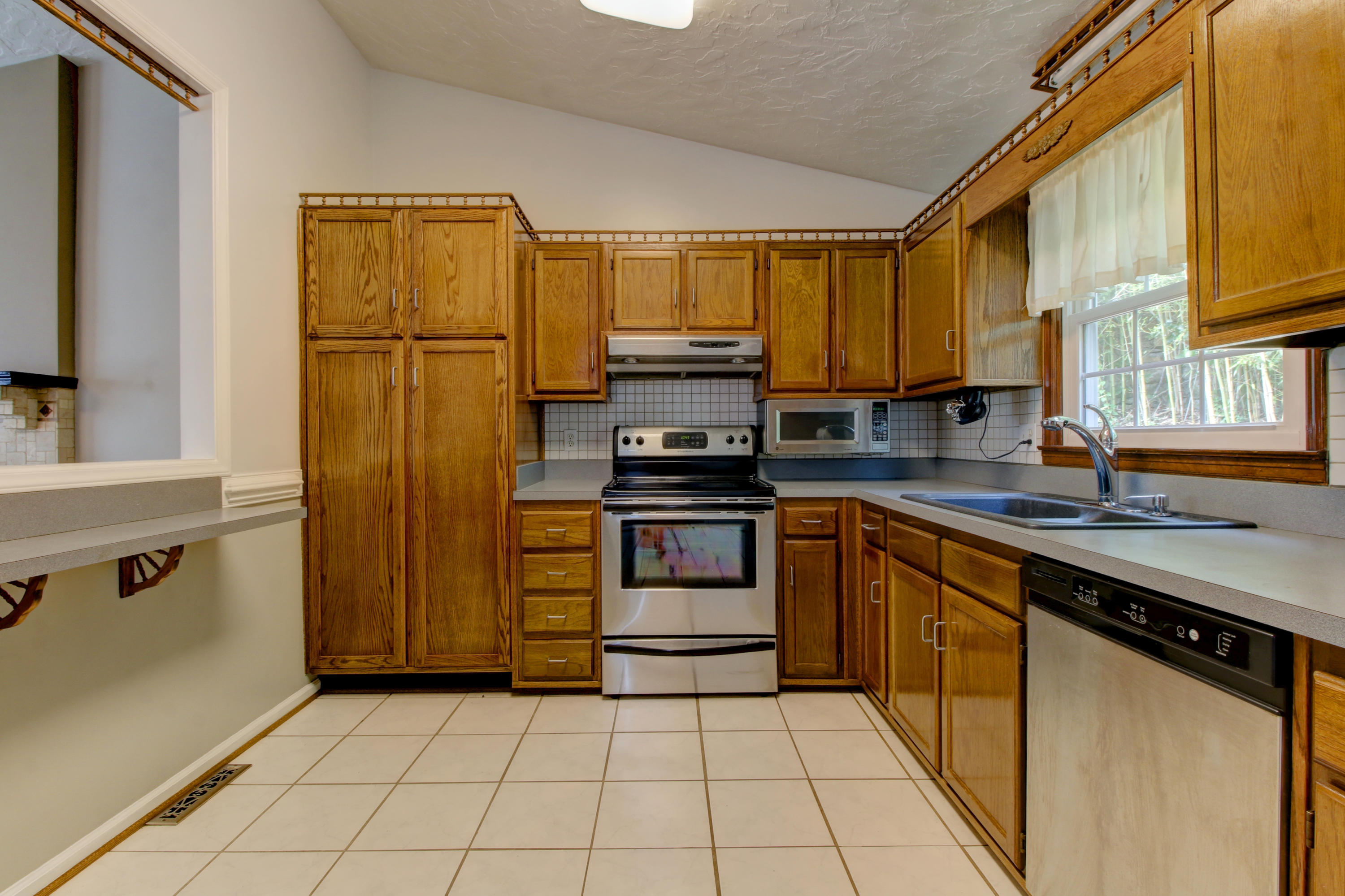 1396 Mountain Pass Road Blue Ridge, VA 24064 - Photo 8 of 28 a kitchen with a refrigerator sink and cabinets