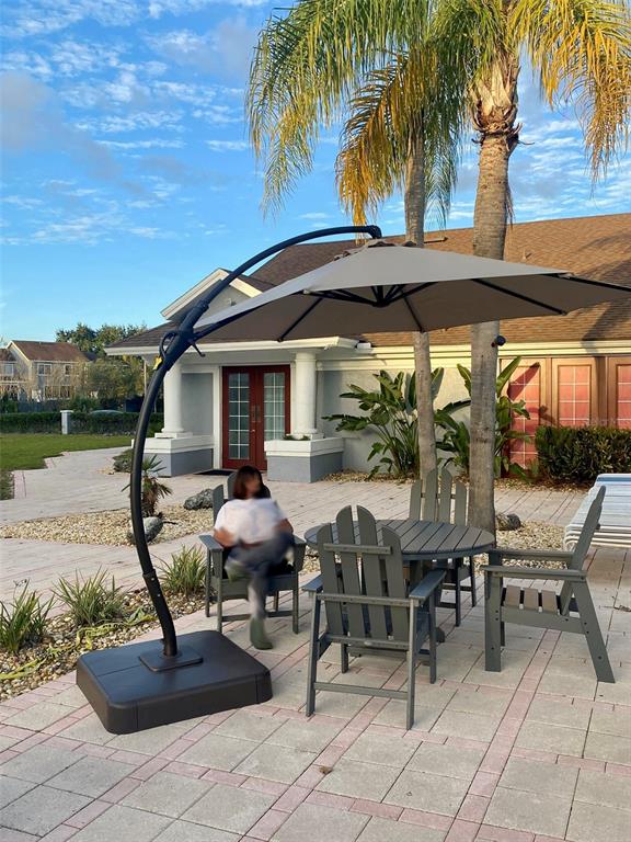 234 Mango Drive, Unit B Davenport, FL 33897 - Photo 12 of 17 a patio with a table and chairs under an umbrella
