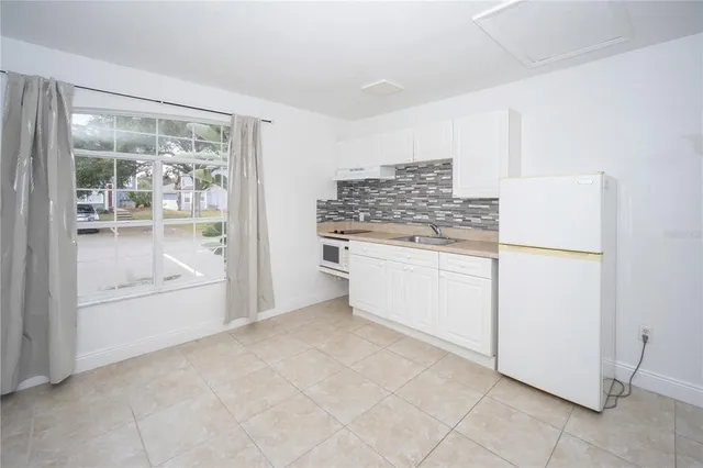 a kitchen with a stove top oven and refrigerator