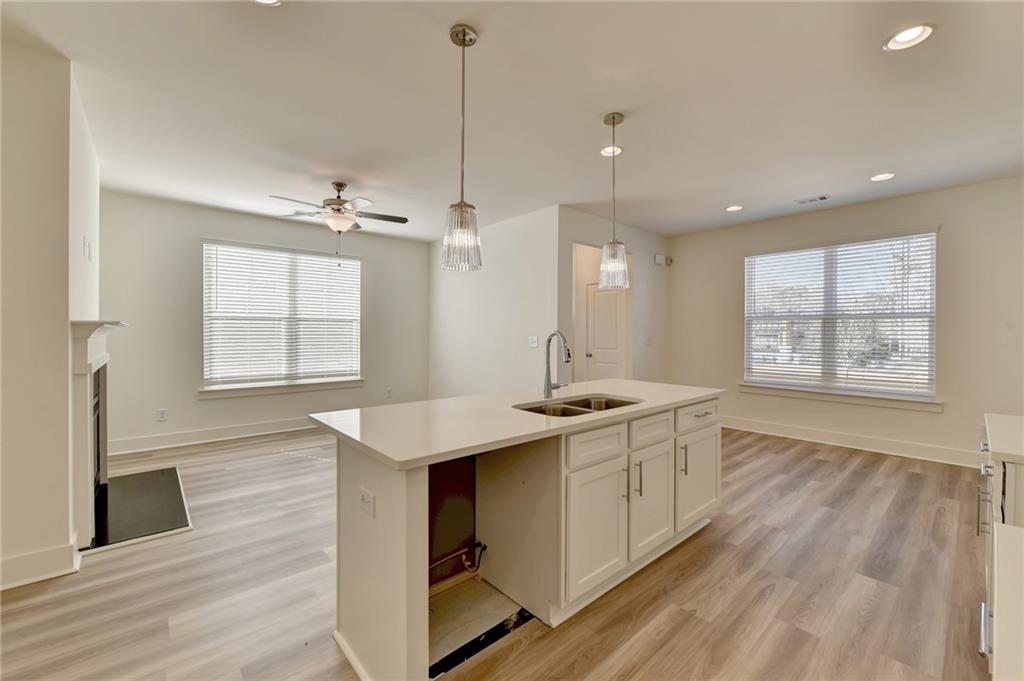 a large kitchen with kitchen island a large island wooden floor and stainless steel appliances
