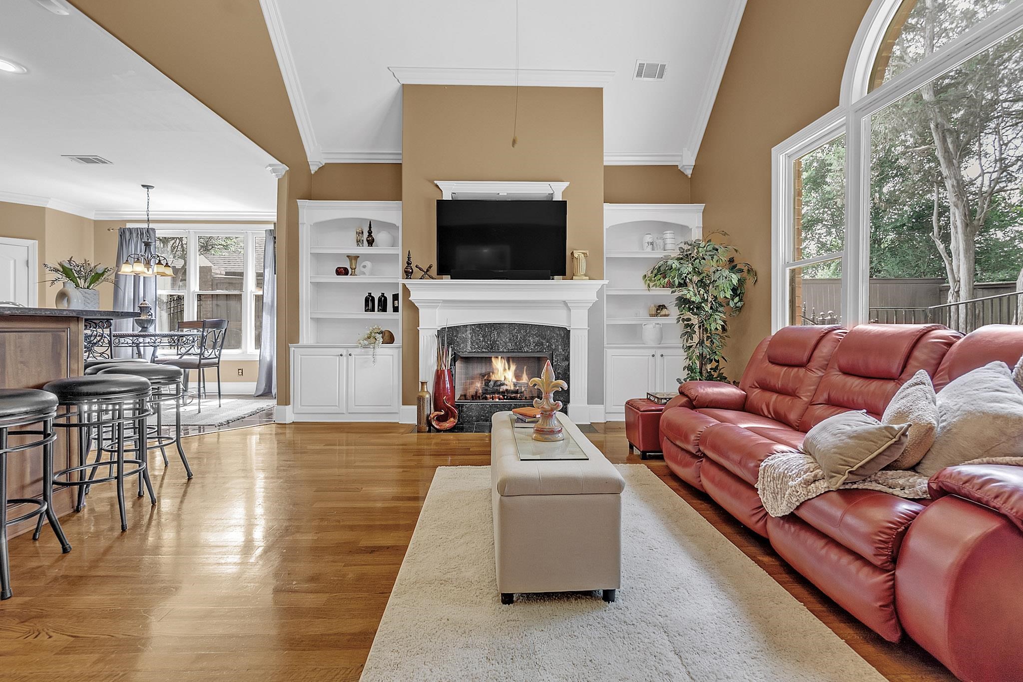 649 Ridge Springs Road Collierville, TN 38017 - Photo 17 of 38 Living area featuring a fireplace with a stone surround and white mantelpiece, flanked by built-in white cabinetry