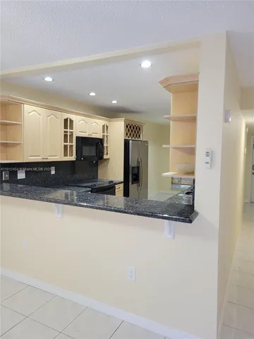 a large kitchen with stainless steel appliances a large counter top