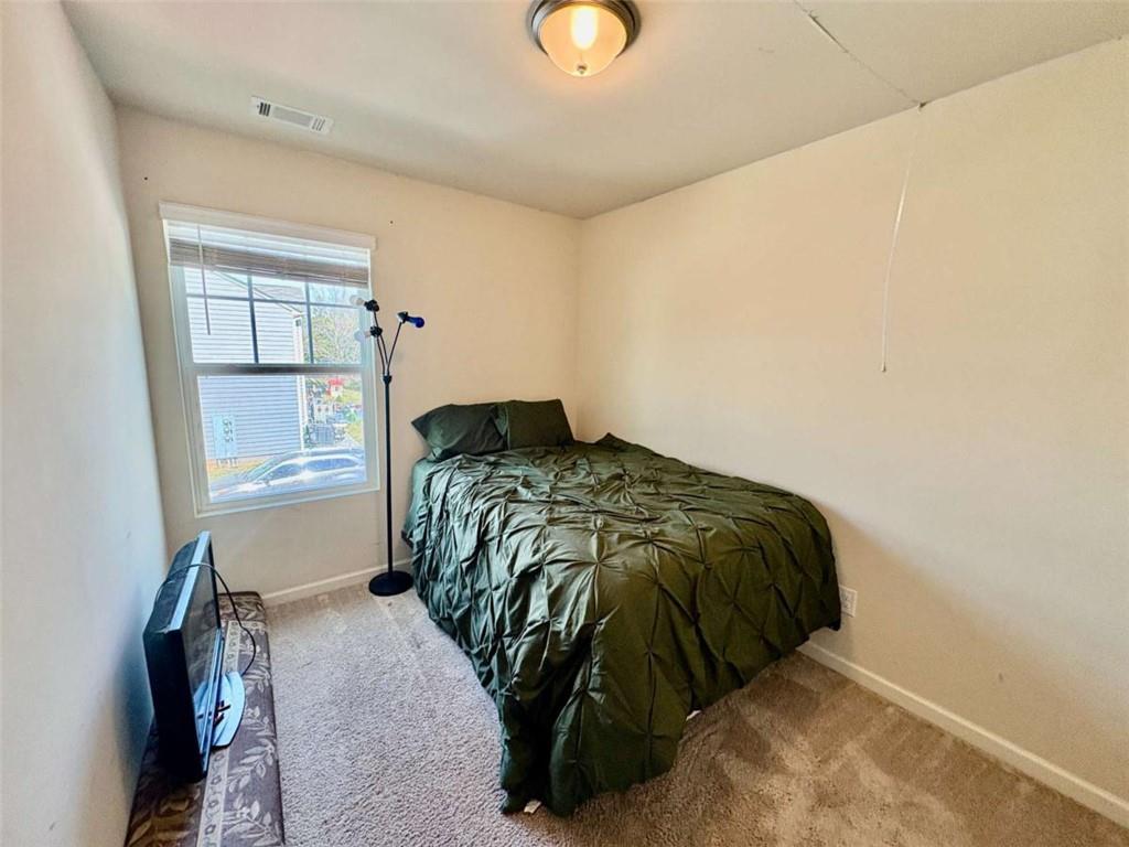 2176 Cypress Lane Southwest Atlanta, GA 30331 - Photo 15 of 17 a bed sitting in a bedroom next to a window and dresser