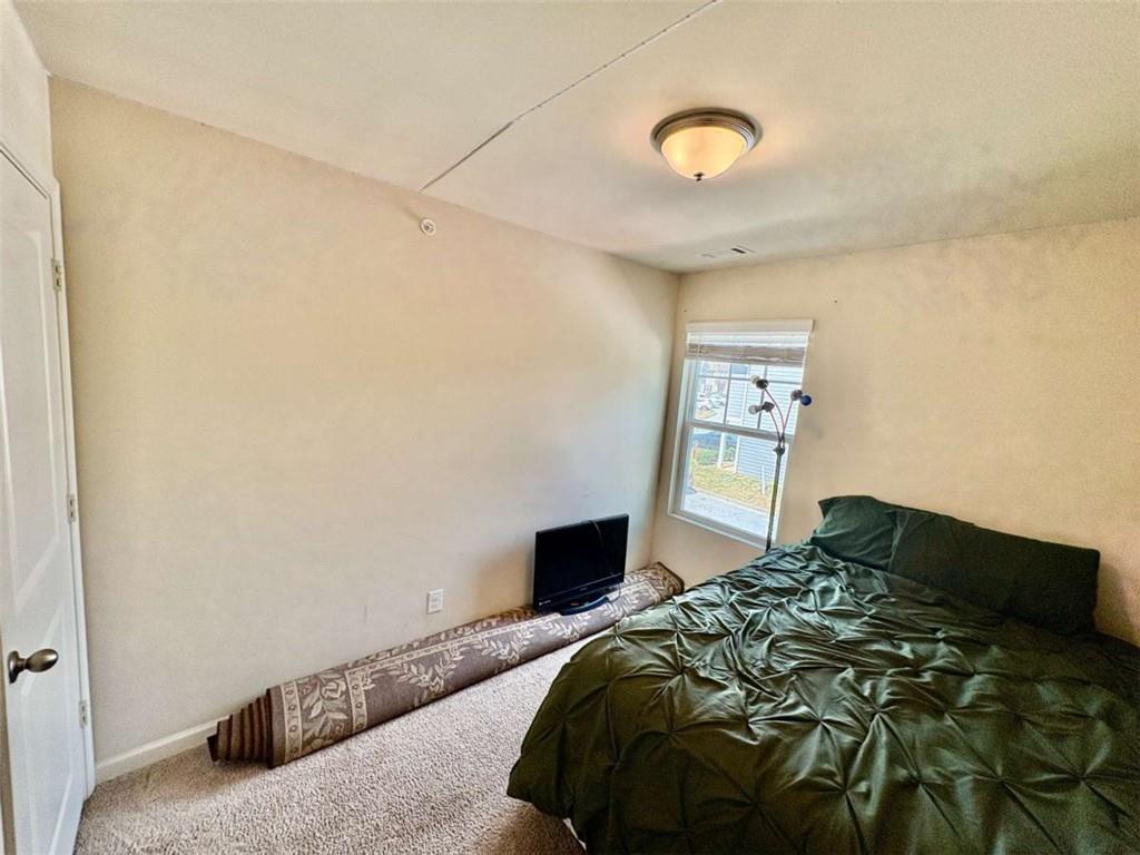 2176 Cypress Lane Southwest Atlanta, GA 30331 - Photo 16 of 17 a bedroom with a bed and a painting on the wall