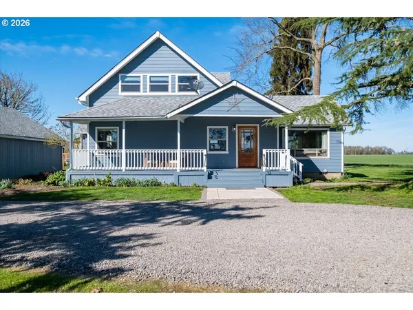 a front view of a house with a yard and potted plants