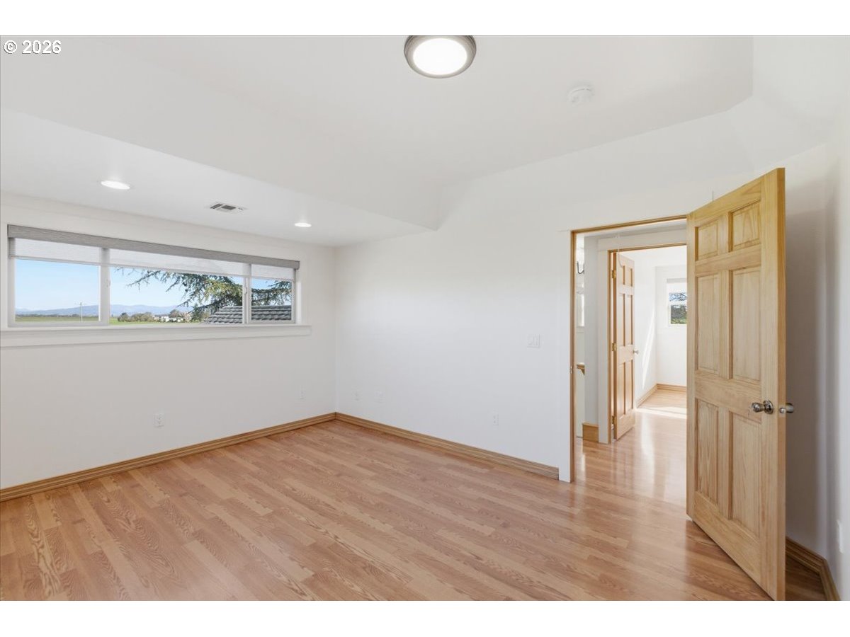 27144 Irish Bend Loop Halsey, OR 97348 - Photo 22 of 48 a view of an empty room with wooden floor and a window