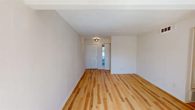 a view of a big room with wooden floor and closet