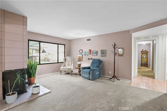 a living room with furniture a large window and a potted plant on table