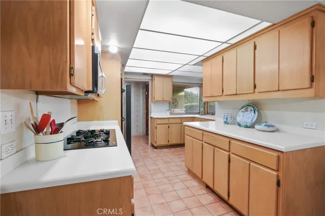 a kitchen with stainless steel appliances granite countertop a stove a sink dishwasher and cabinets with wooden floor