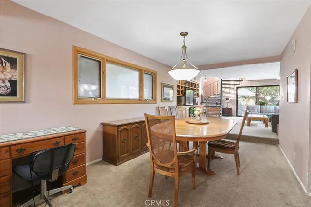 a dining room with furniture a chandelier and window
