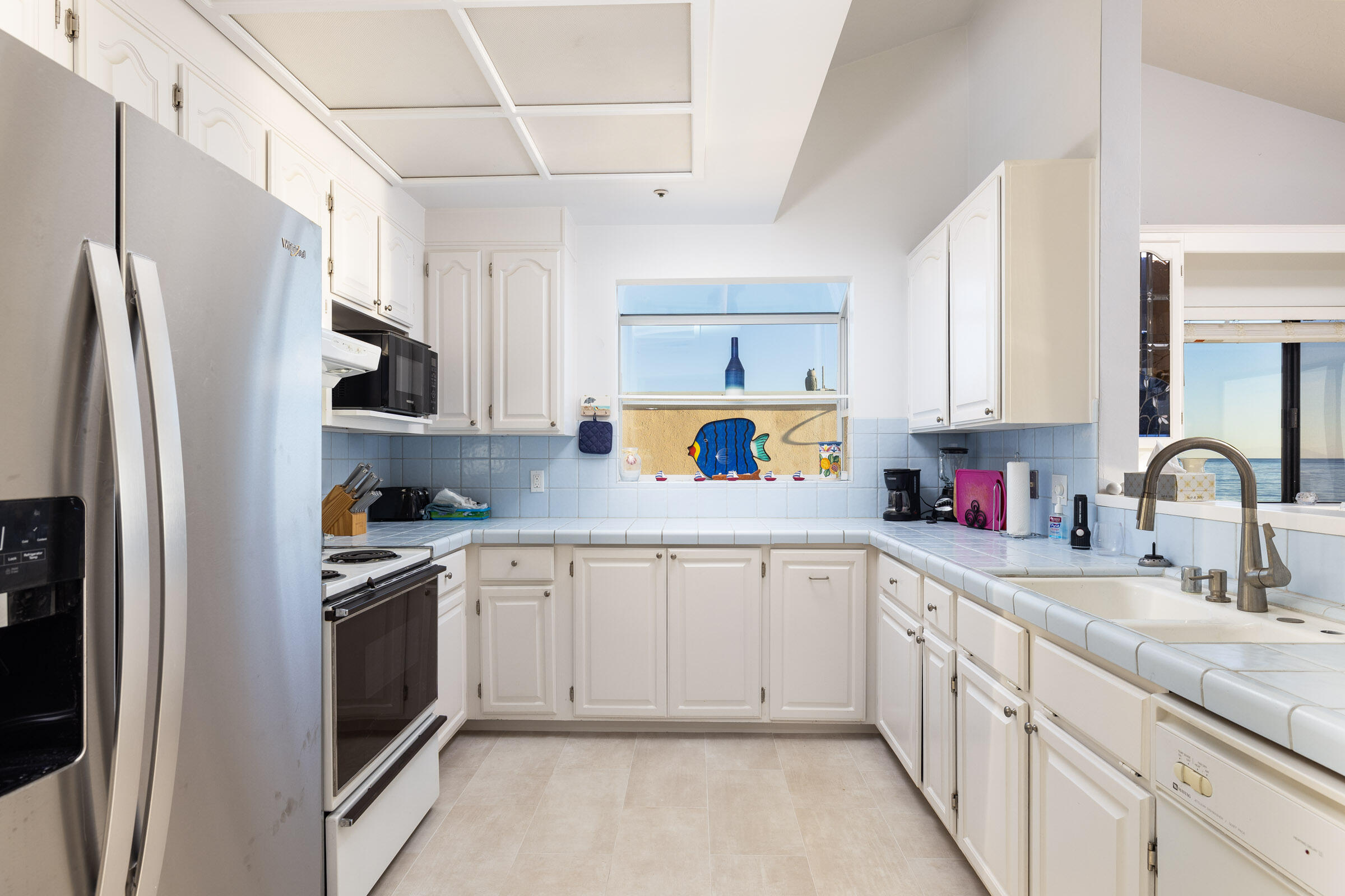 4925 Sandyland Road, Unit F Carpinteria, CA 93013 - Photo 15 of 19 a kitchen with white cabinets and white appliances