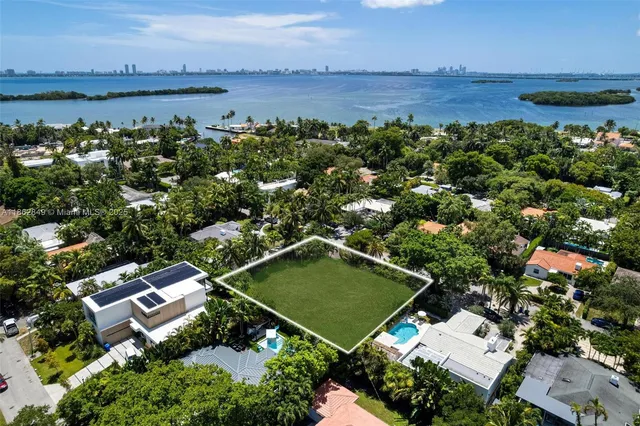an aerial view of a residential houses with outdoor space and lake view