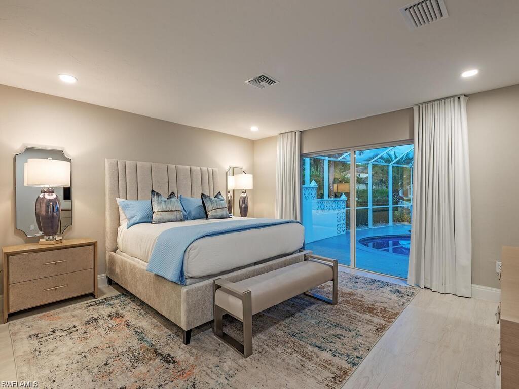 4856 Crayton Road Naples, FL 34103 - Photo 16 of 24 a bedroom with a bed and a mirror