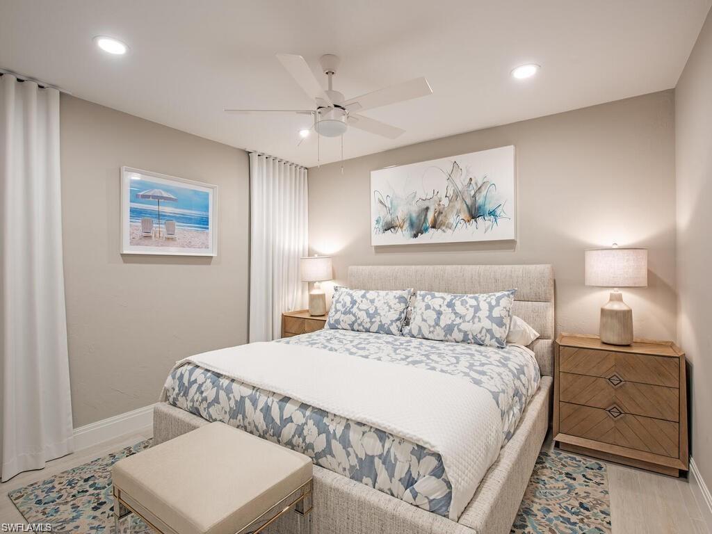 4856 Crayton Road Naples, FL 34103 - Photo 20 of 24 a bedroom with a large bed and a lamp
