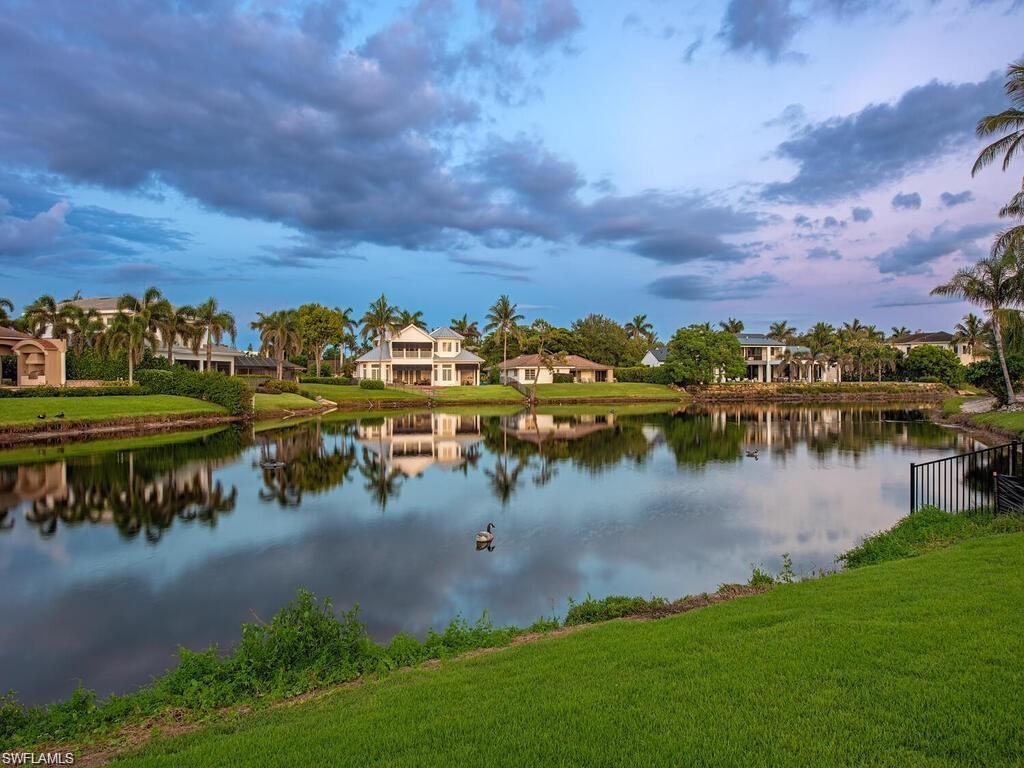 4856 Crayton Road Naples, FL 34103 - Photo 2 of 24 a view of a lake with houses in the back