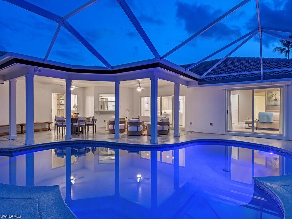 4856 Crayton Road Naples, FL 34103 - Photo 5 of 24 a view of a swimming pool with a table and chairs