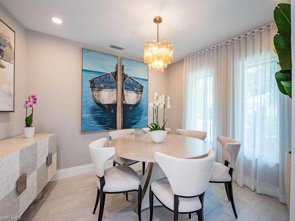 4856 Crayton Road Naples, FL 34103 - Photo 10 of 24 a view of a dining room with furniture window and wooden floor