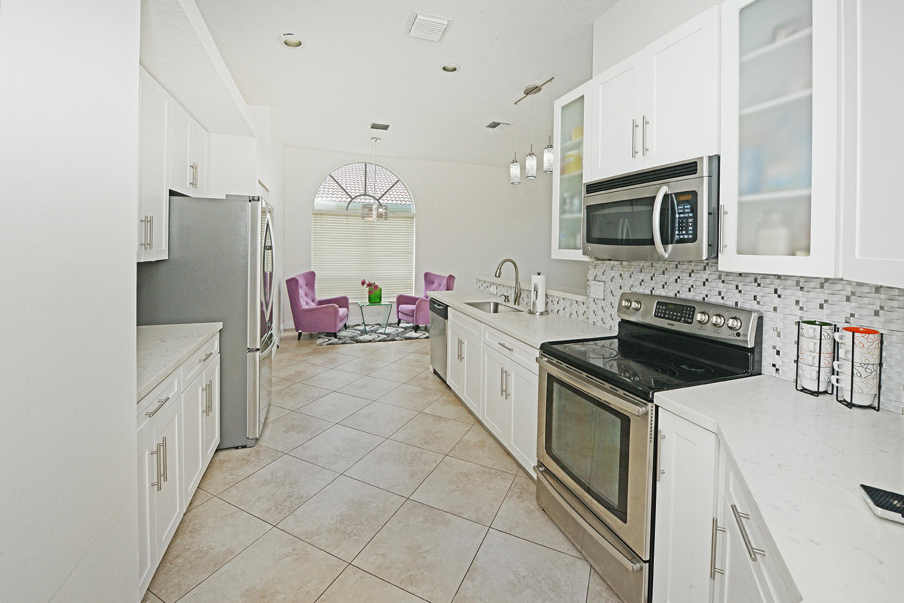 9513 Lake Serena Drive Boca Raton, FL 33496 - Photo 13 of 26 a kitchen with granite countertop a sink stove and cabinets