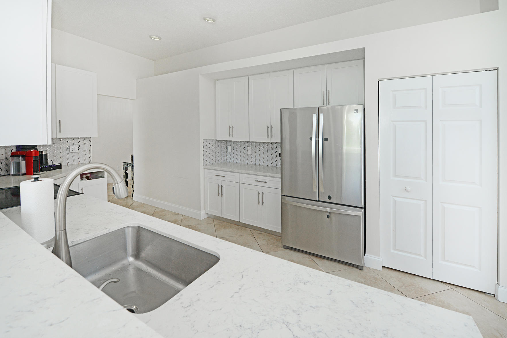 9513 Lake Serena Drive Boca Raton, FL 33496 - Photo 14 of 26 a kitchen with granite countertop a refrigerator sink and cabinets
