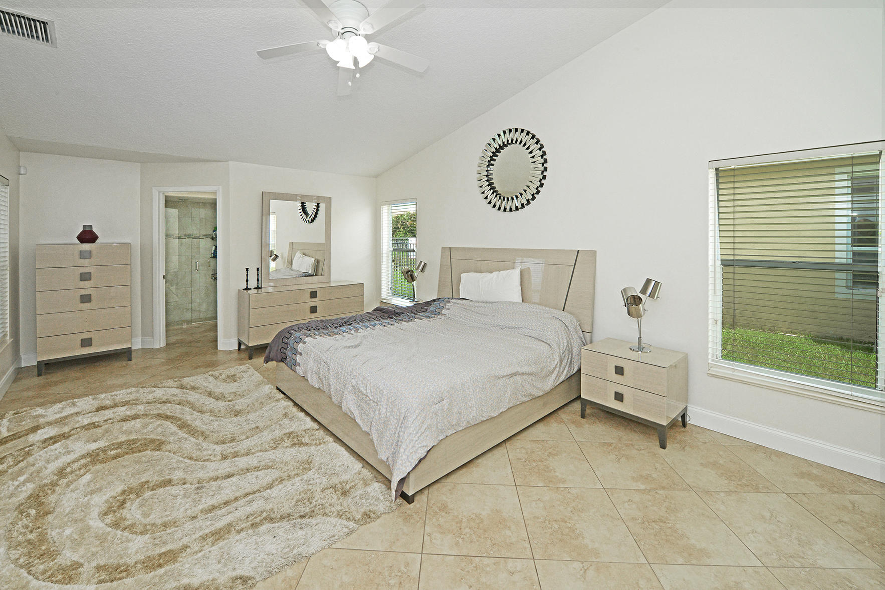 9513 Lake Serena Drive Boca Raton, FL 33496 - Photo 15 of 26 a bedroom with a bed and a chandelier