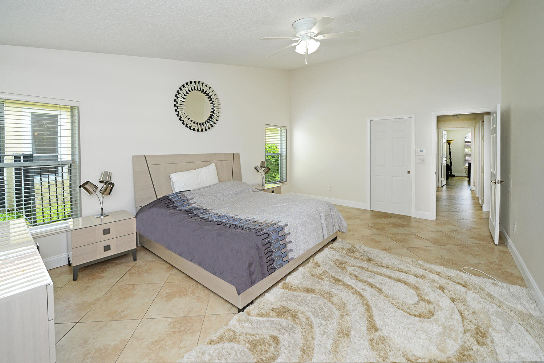 9513 Lake Serena Drive Boca Raton, FL 33496 - Photo 16 of 26 a spacious bedroom with a bed and window