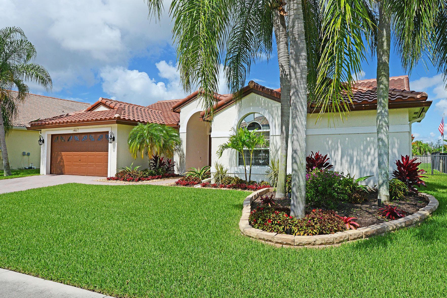 9513 Lake Serena Drive Boca Raton, FL 33496 - Photo 4 of 26 a front view of yellow house with a yard and potted plants