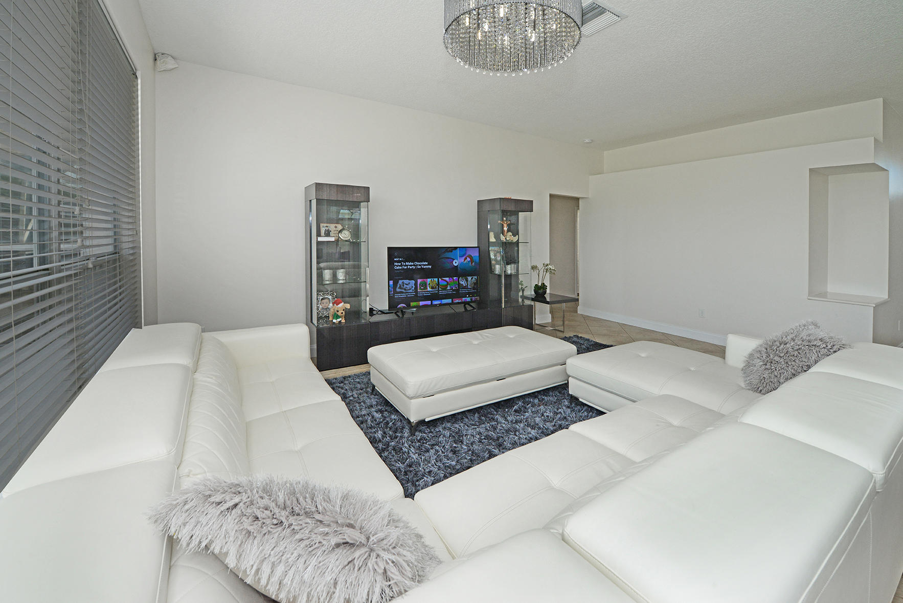 9513 Lake Serena Drive Boca Raton, FL 33496 - Photo 7 of 26 a bedroom with a large bed and a chandelier