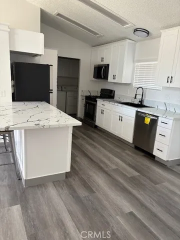 a large kitchen with cabinets stove top oven and sink