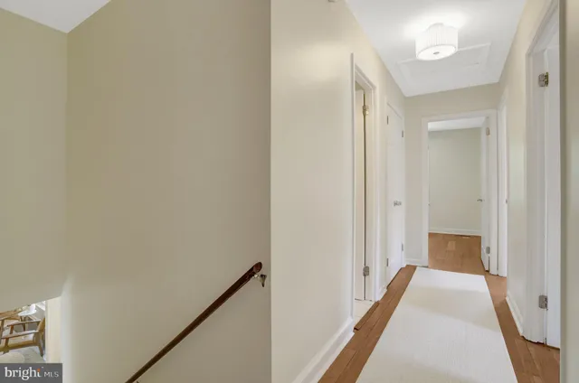 a view of a hallway with wooden floor and staircase