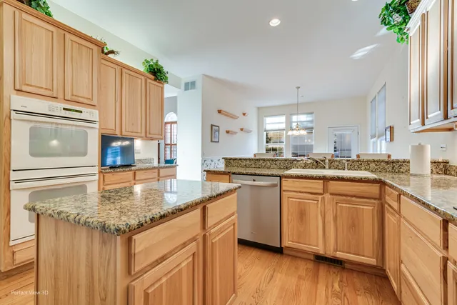 a kitchen with stainless steel appliances granite countertop a sink stove and cabinets