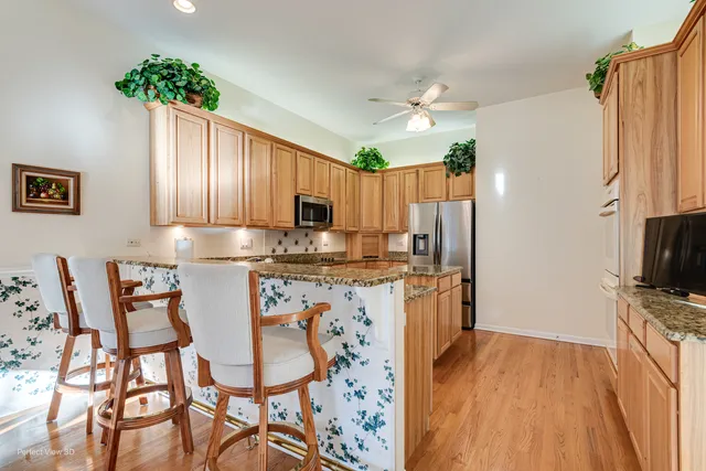 a kitchen with granite countertop stainless steel appliances a refrigerator and microwave