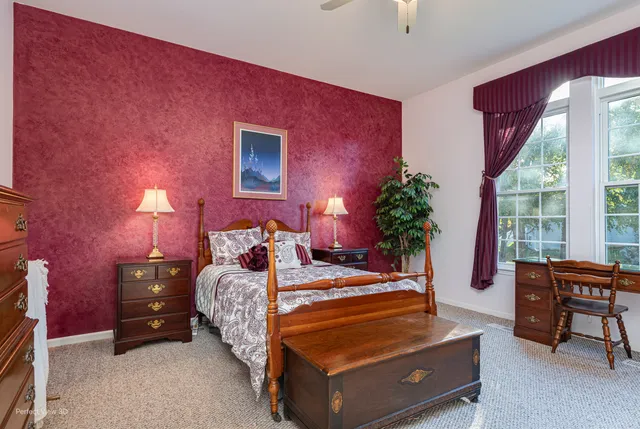 a bedroom with a bed and a table chair