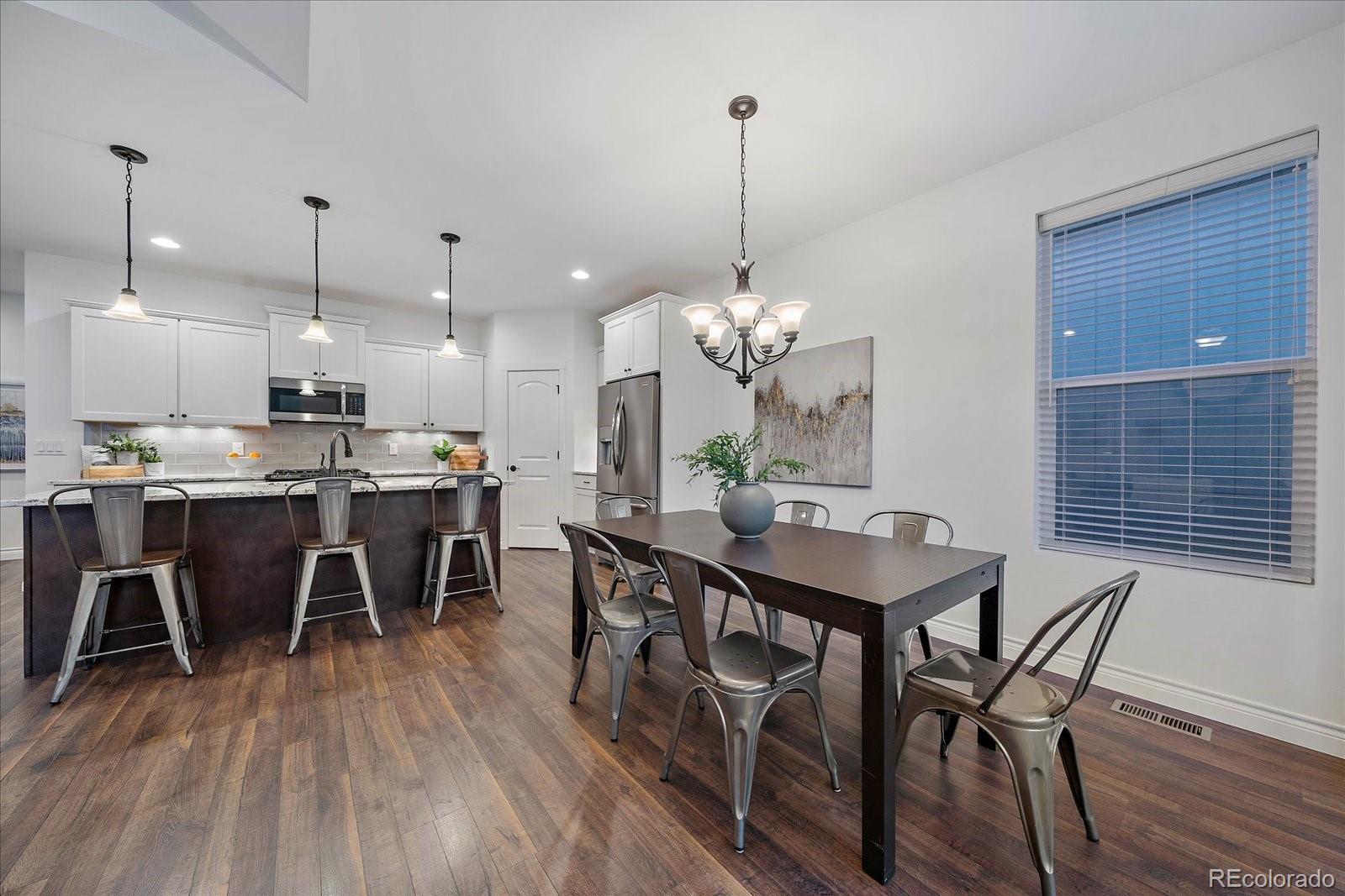 11526 Colony Loop Parker, CO 80138 - Photo 11 of 29 a view of a dining room and livingroom with furniture wooden floor a chandelier