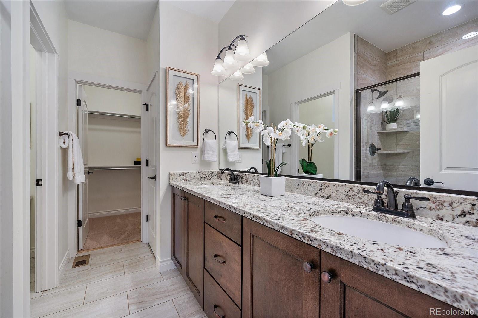 11526 Colony Loop Parker, CO 80138 - Photo 20 of 29 a bathroom with a granite countertop double vanity sink mirror and shower