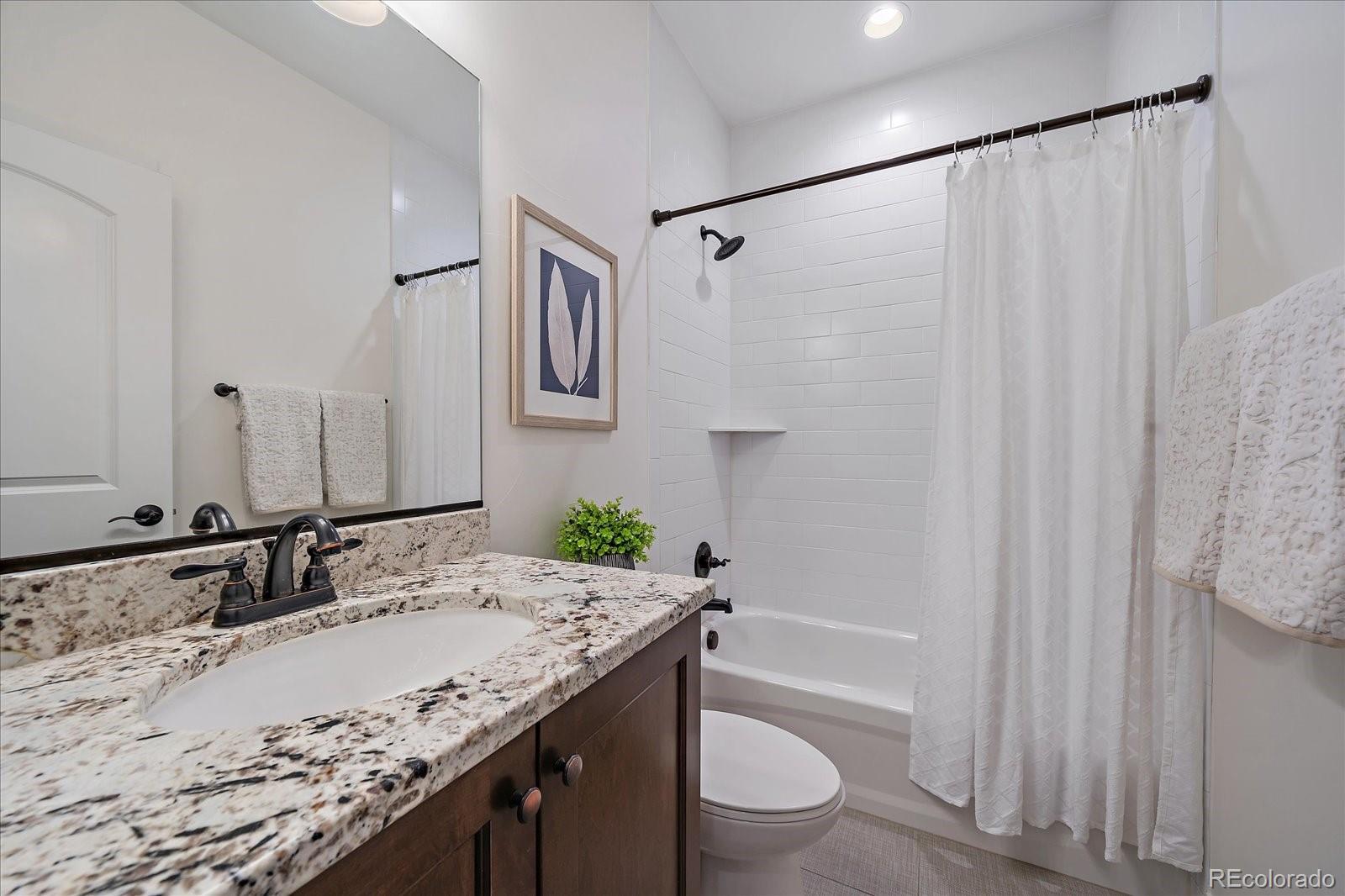 11526 Colony Loop Parker, CO 80138 - Photo 24 of 29 a bathroom with a granite countertop sink toilet and shower