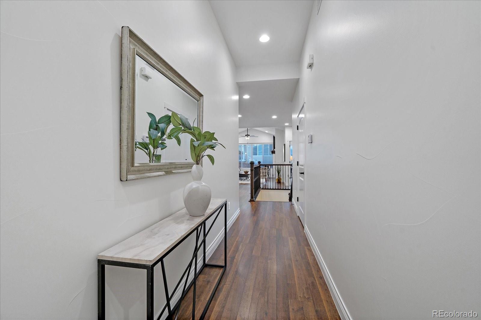 11526 Colony Loop Parker, CO 80138 - Photo 3 of 29 a view of a hallway with wooden floor and staircase