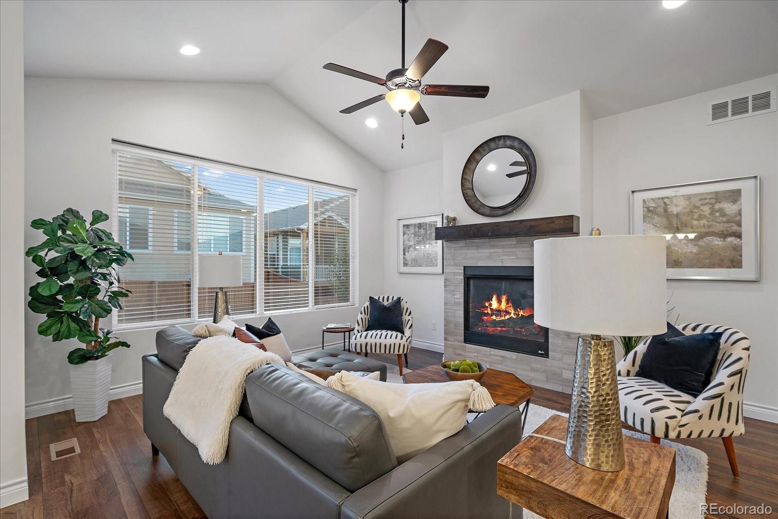 11526 Colony Loop Parker, CO 80138 - Photo 7 of 29 a living room with furniture a clock and a fireplace