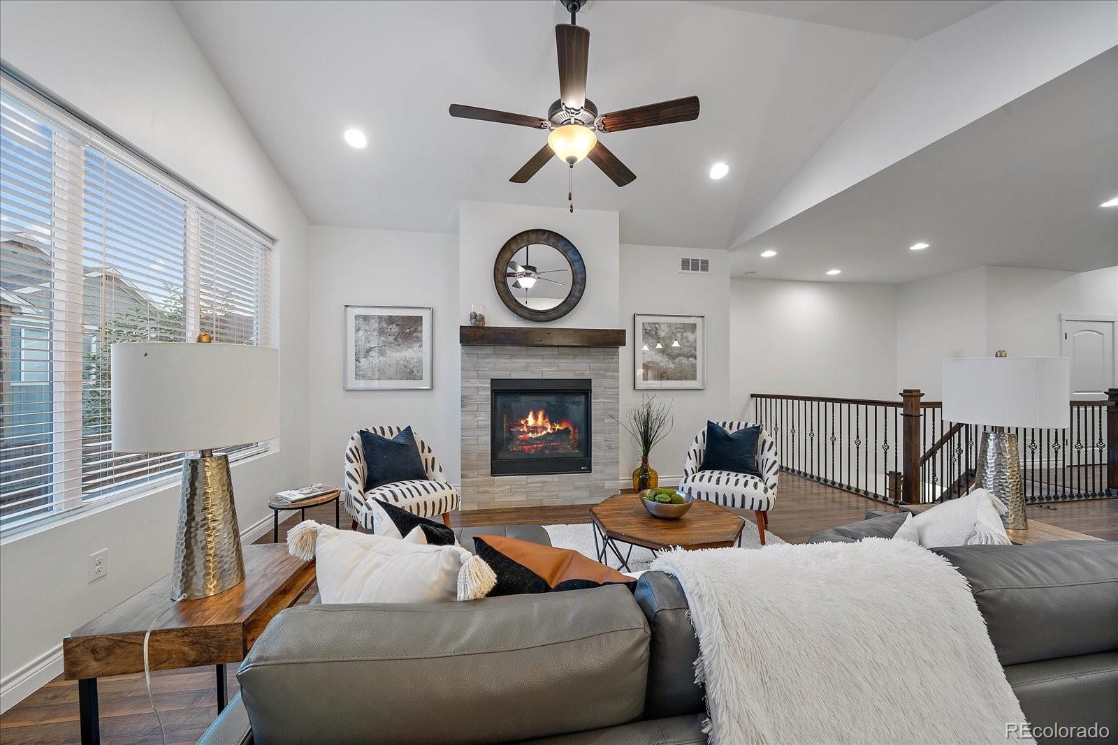 11526 Colony Loop Parker, CO 80138 - Photo 8 of 29 a living room with furniture a clock and a fireplace