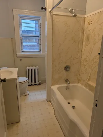 a bathroom with a tub a toilet and a shower