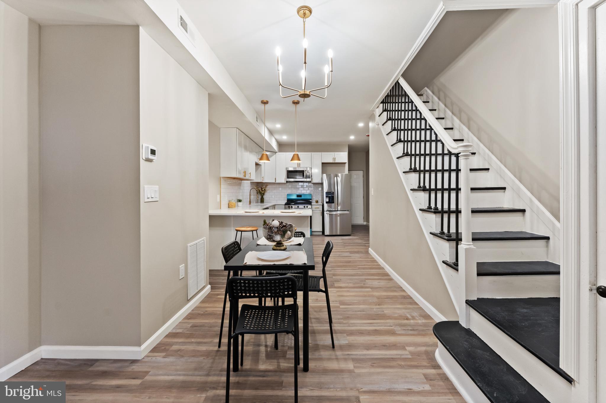 602 Denison Street Baltimore, MD 21229 - Photo 5 of 17 a view of a hallway with wooden floor and staircase