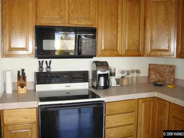 3145 Alpine Creek Road Reno, NV 89519 - Photo 3 of 9 a kitchen with stainless steel appliances granite countertop a sink stove and microwave