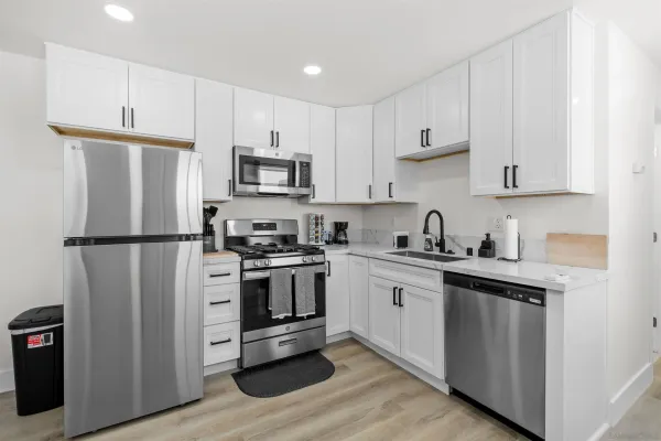 a kitchen with stainless steel appliances granite countertop a refrigerator stove a sink and a microwave