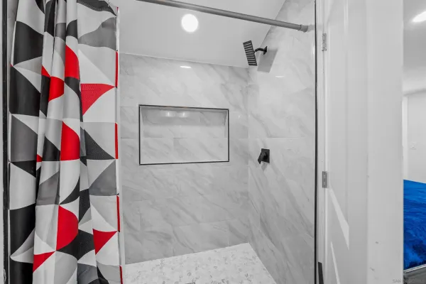 a bathroom with a granite countertop sink a toilet a mirror and shower