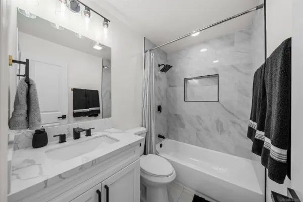 a bathroom with a sink a toilet a mirror and shower