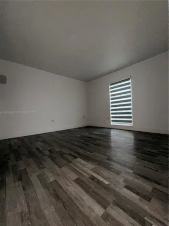 a view of a room with wooden floor and a window