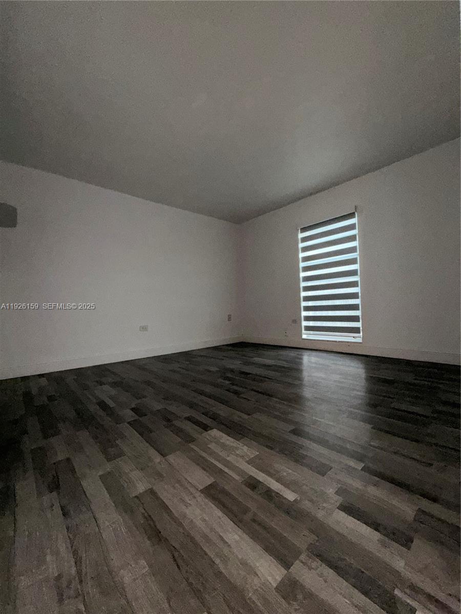 7250 Southwest 94th Place, Unit B8 Miami, FL 33173 - Photo 14 of 18 a view of a room with wooden floor and a window