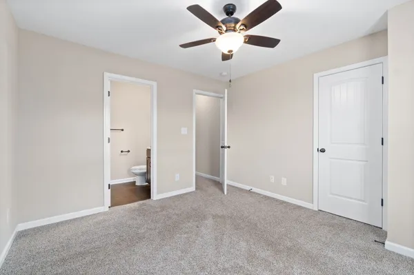 an empty room with chandelier fan and closet