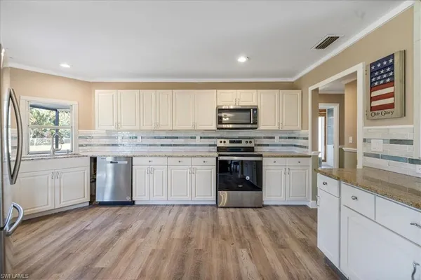 a kitchen with stainless steel appliances a stove sink and cabinets